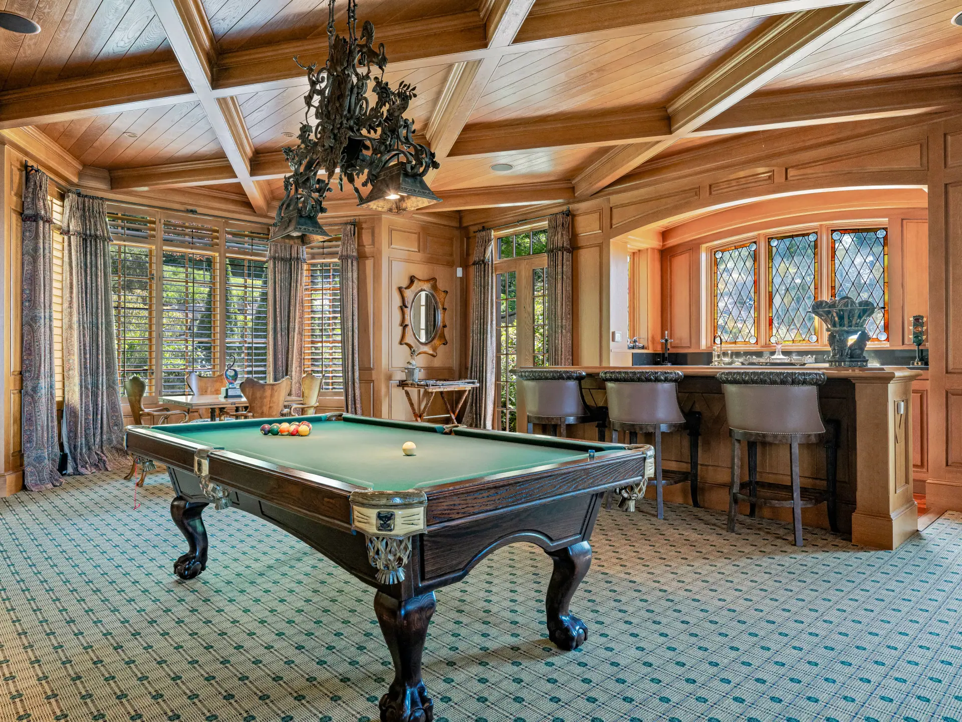 Billiards room with coffered wood ceiling and custom bar